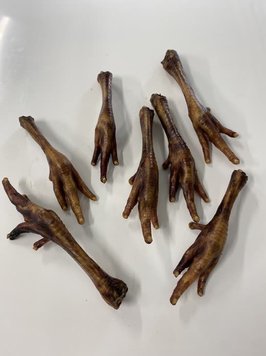Dried chicken feet natural dog treats laid out on a plain white background